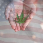 Mains ouvertes tenant une feuille de cannabis avec un drapeau américain en transparence à l’arrière-plan, illustrant la question de la reclassification du cannabis aux États-Unis